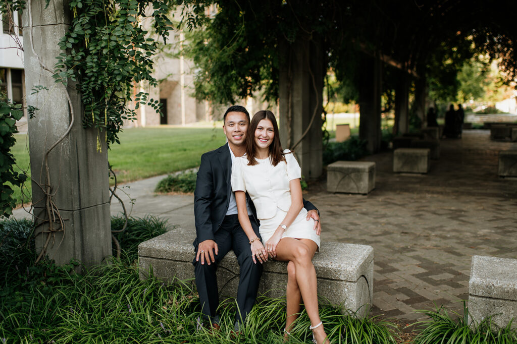 Couple sitting on the bench under a shaded archway at Notre Dame.