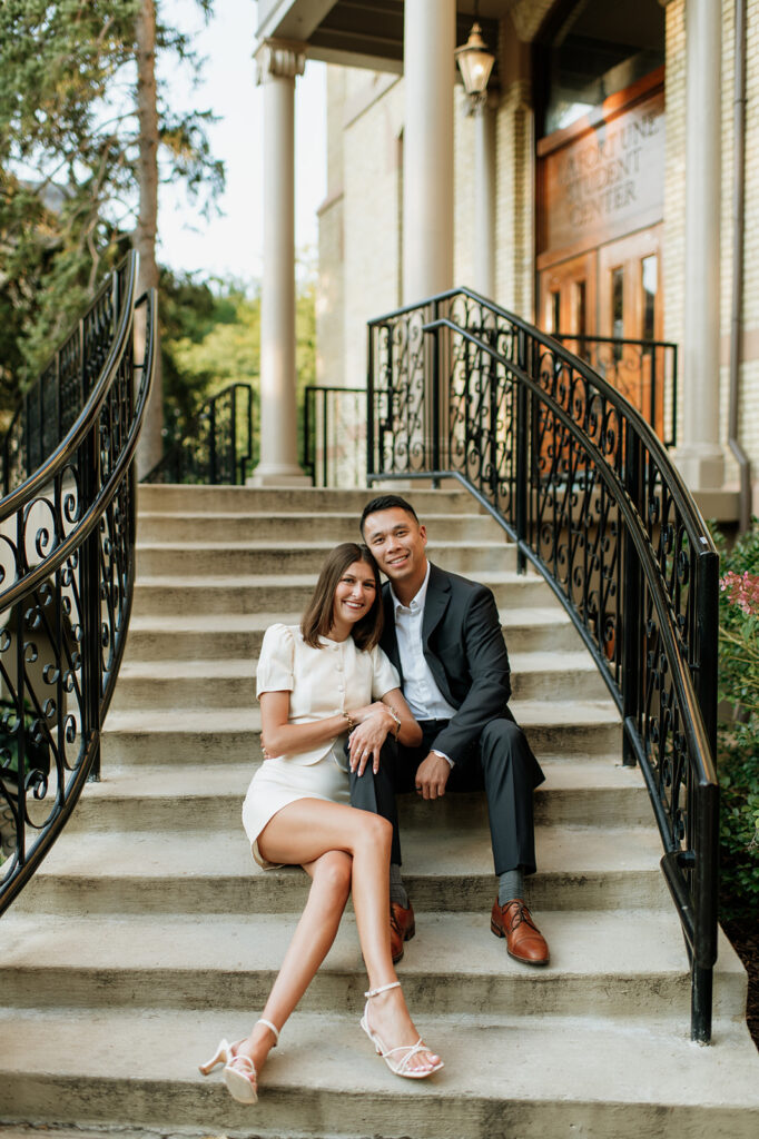 Couple sitting together on the staircase outside LaFortune during their University of Notre Dame engagement photos.
