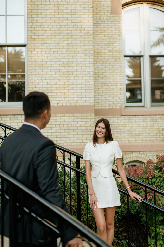 Couple posing on opposite sides of the staircase railings at LaFortune Student Center.