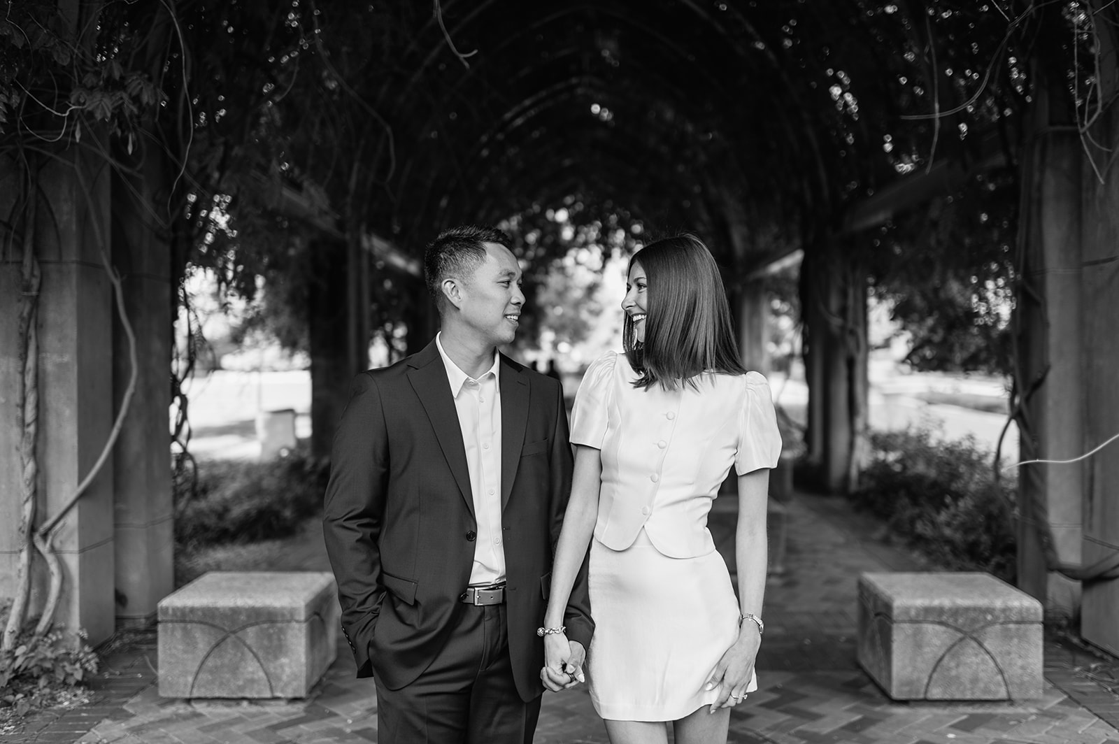 Couple smiling at each other under the vine tunnel at Notre Dame.