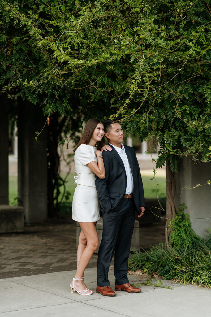 Couple embracing near ivy-covered columns at the University of Notre Dame.