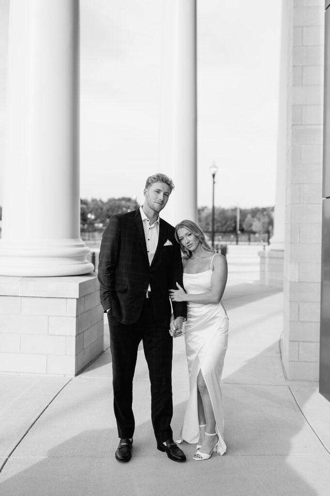Black and white photo of a couple posing at the courthouse columns in Goshen, Indiana