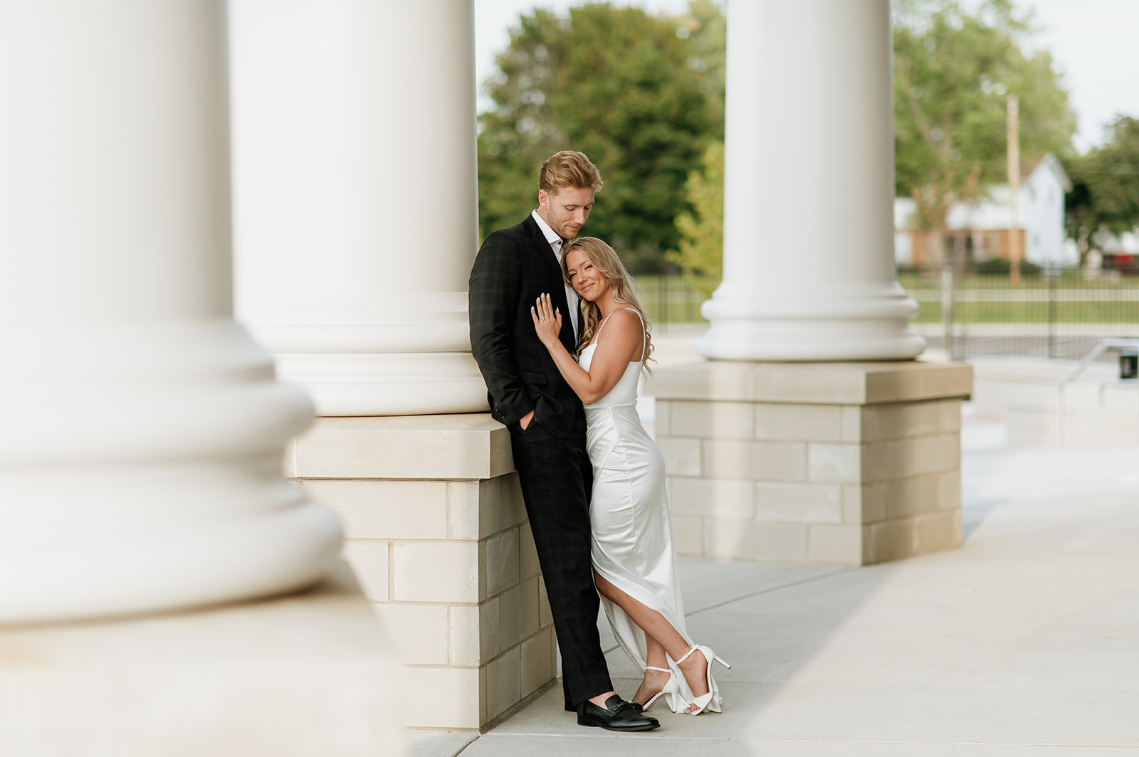 Couple leaning against the columns at the courthouse