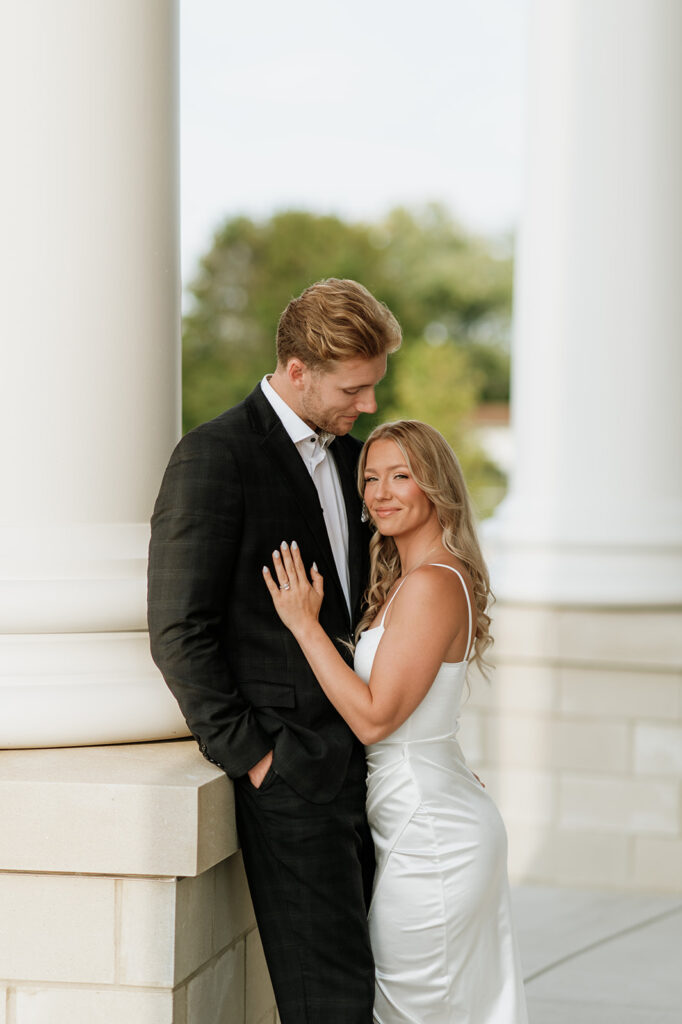 Couple leaning against the columns at the courthouse