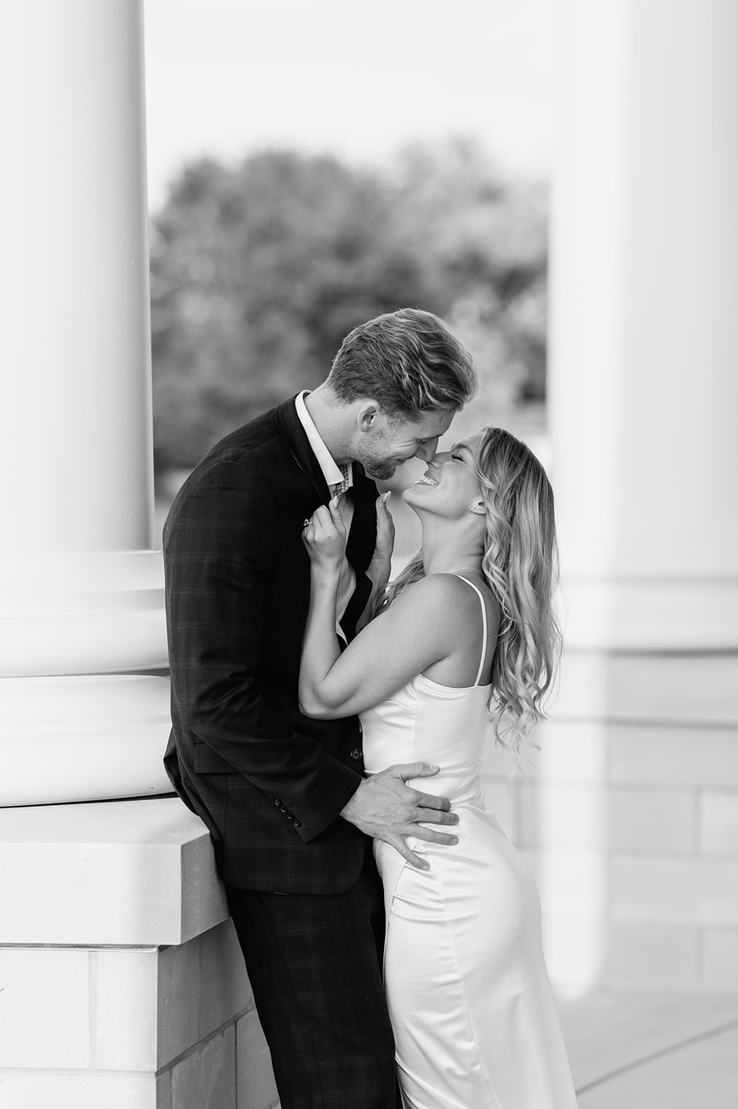 Black and white photo of a couple touching noses and leaning into each other