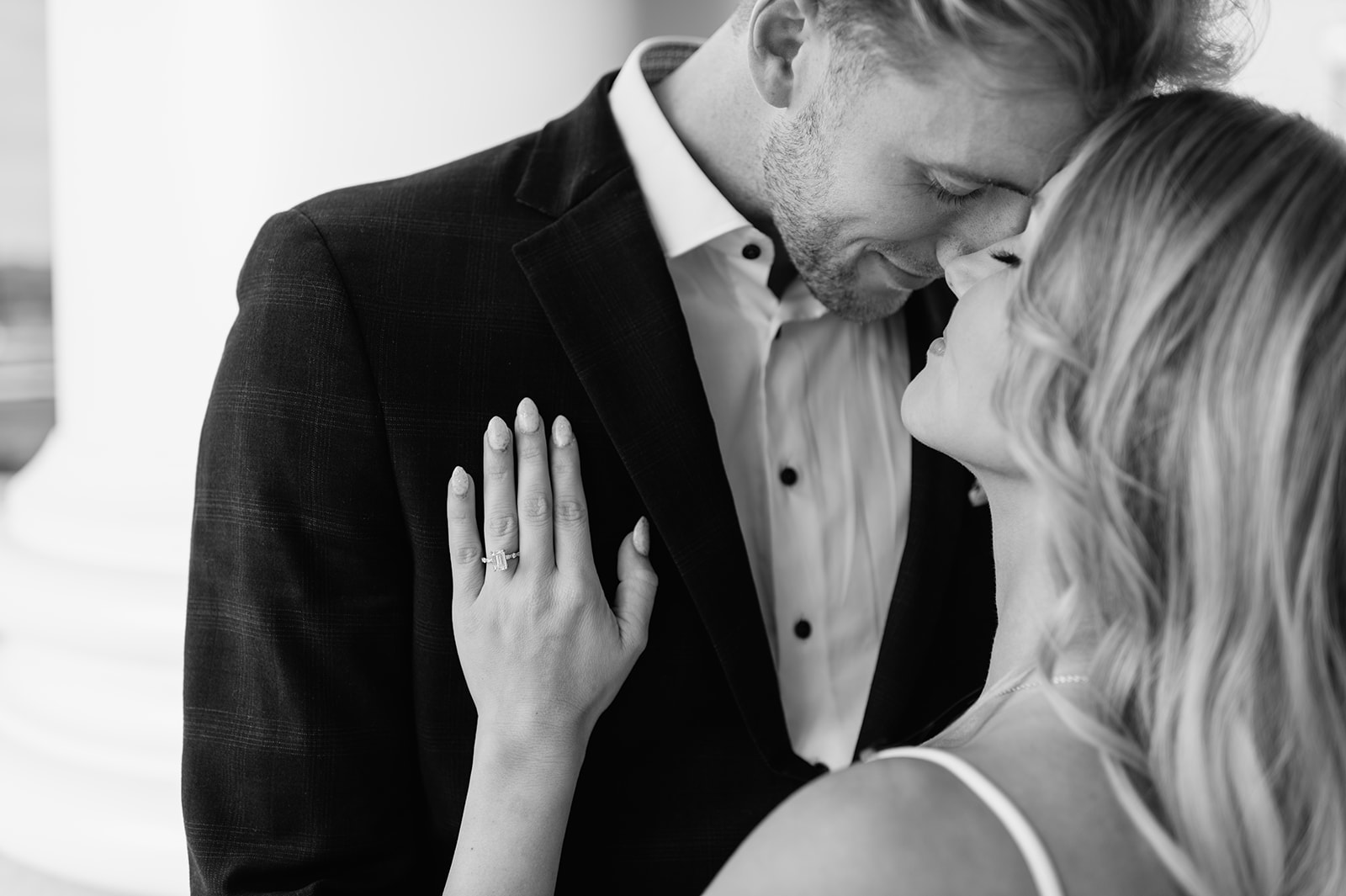 Close-up of engagement ring as the couple leans in for a soft moment together