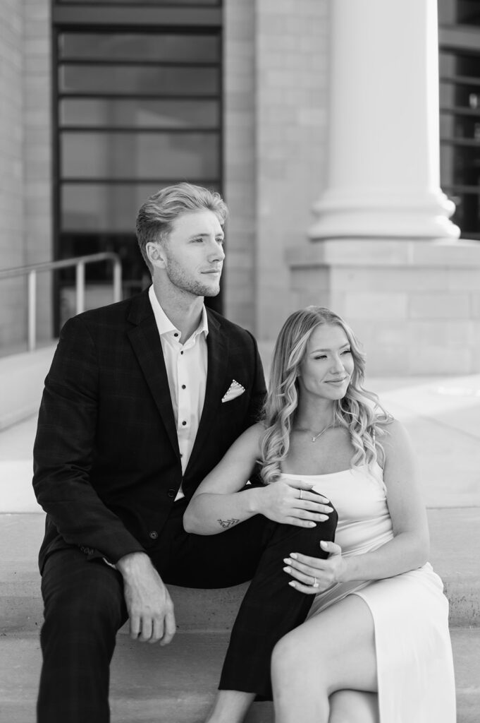 Black and white photo of a couple sitting on the steps of the courthouse