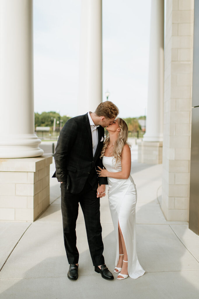 Couple kissing at the courthouse columns in Goshen, Indiana