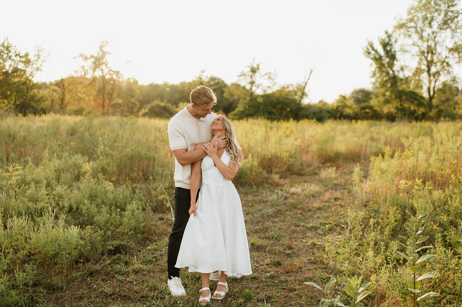 Couple standing in a grassy field during golden hour for their Goshen, Indiana engagement photos