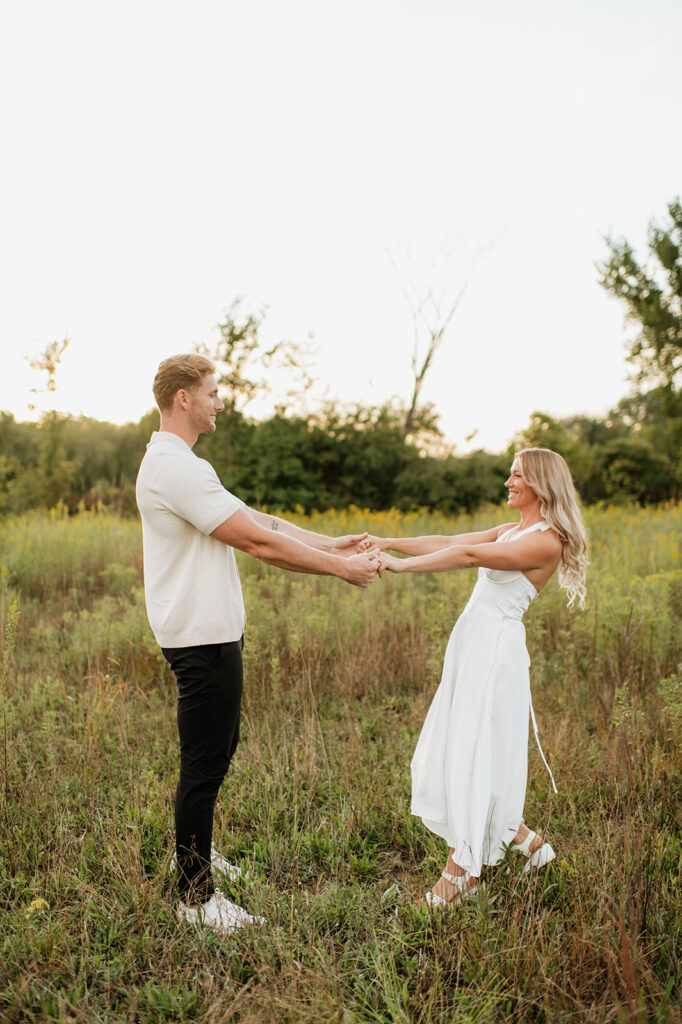Couple dancing in the tall grass at golden hour