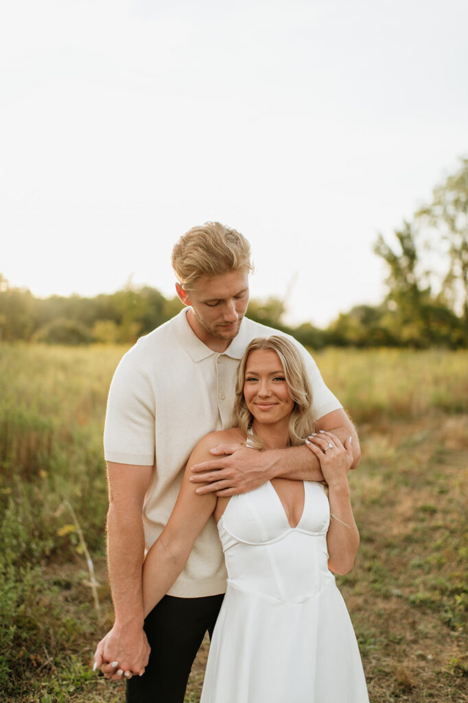 Couple standing in a grassy field during golden hour for their Goshen, Indiana engagement photos
