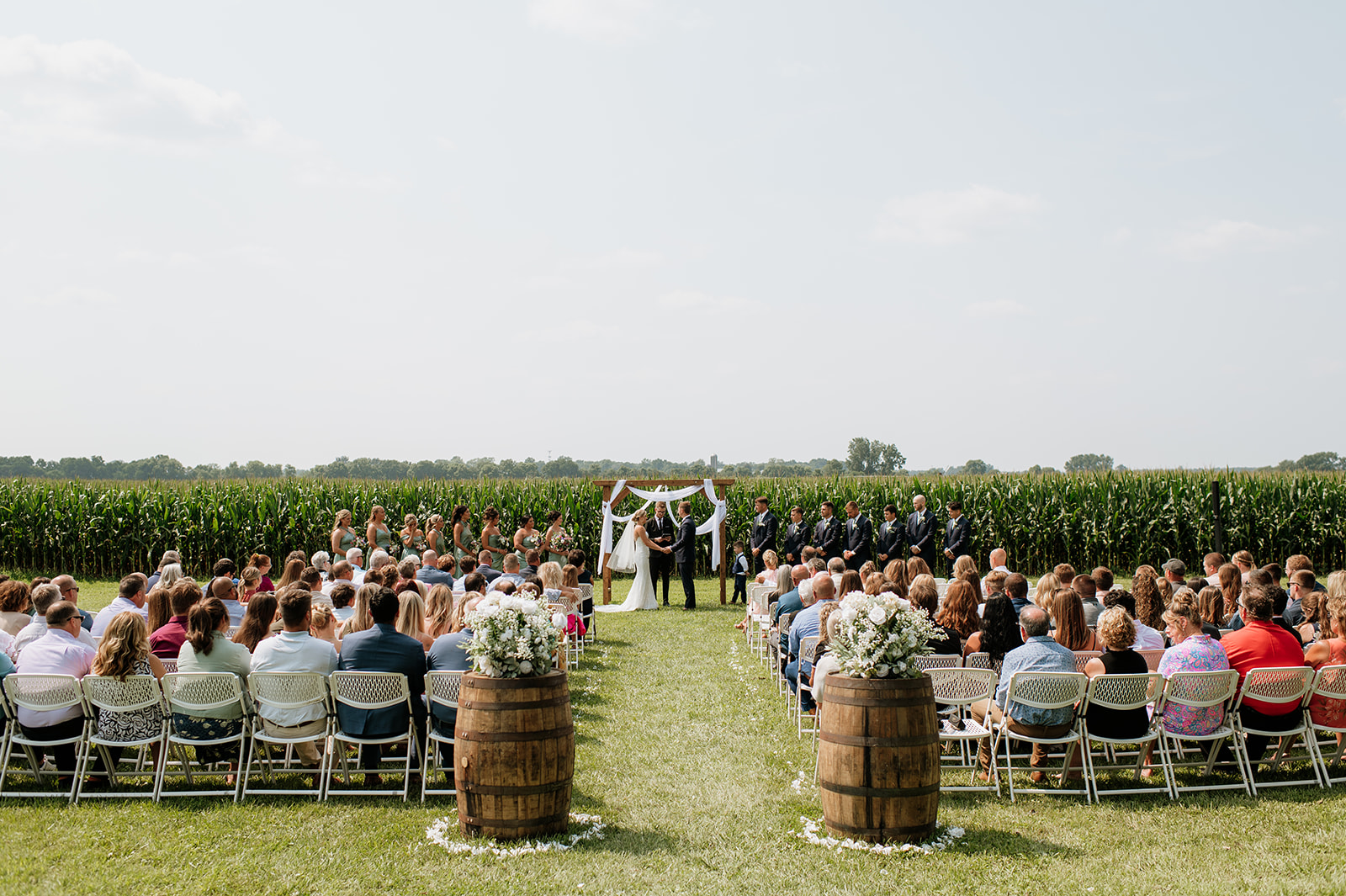 Wide view of ceremony setup in front of cornfield at Rock Run Creek Barn in Goshen, Indiana.