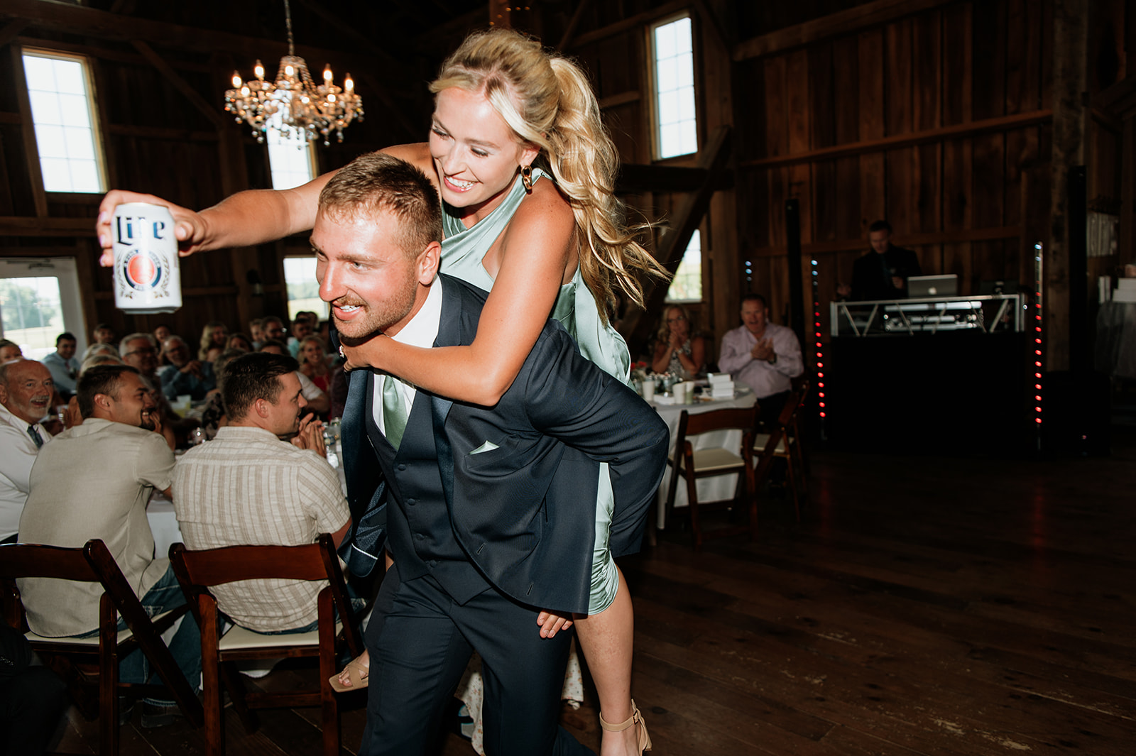Bridesmaid riding into the reception on the groomsmen back