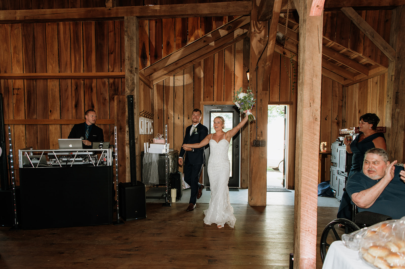 Bride and groom entering their Rock Run Creek Barn wedding reception with cheers from guests.