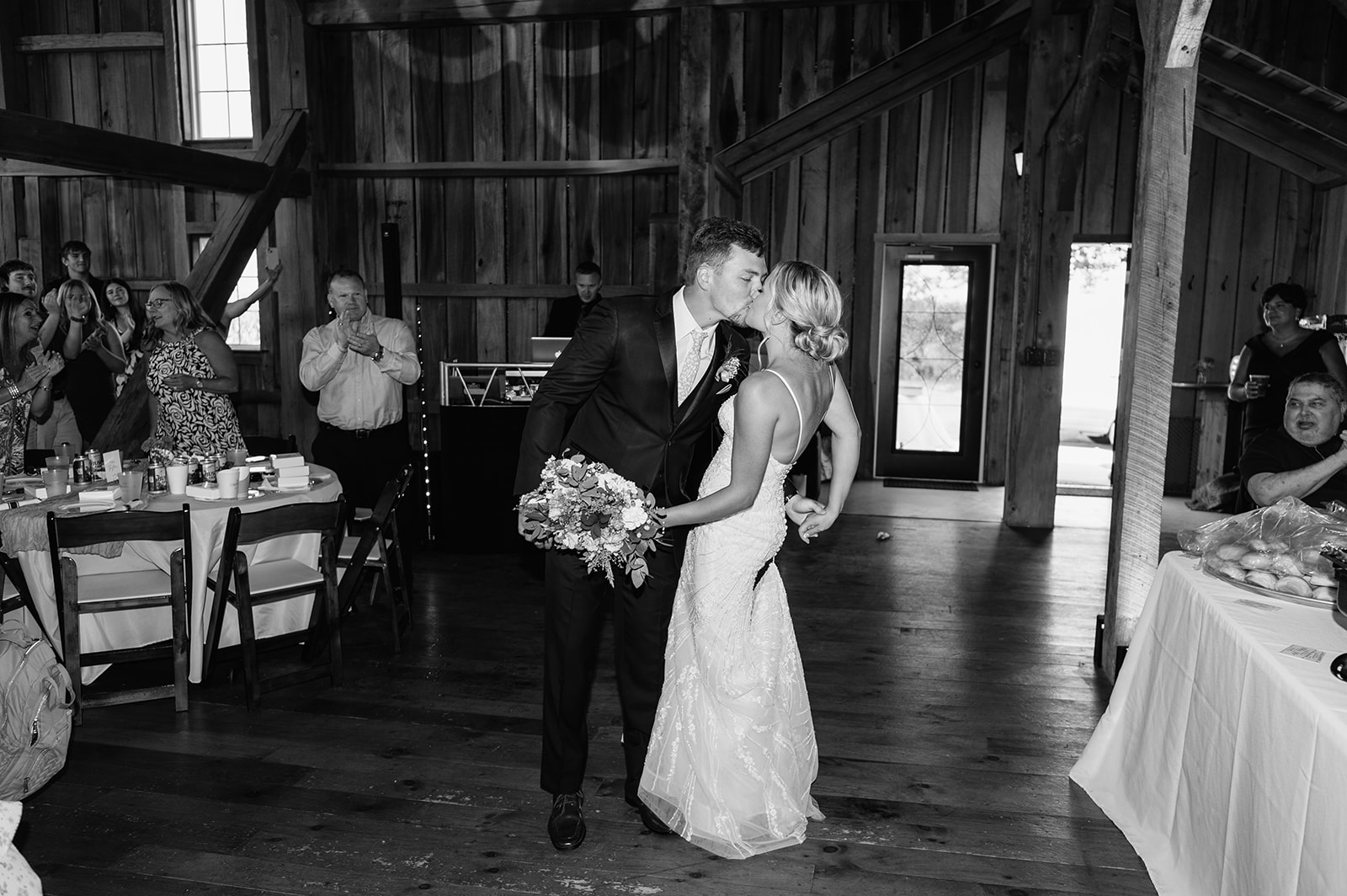 Bride and groom sharing a kiss during their grand entrance into the Event Barn at Rock Run Creek wedding reception.