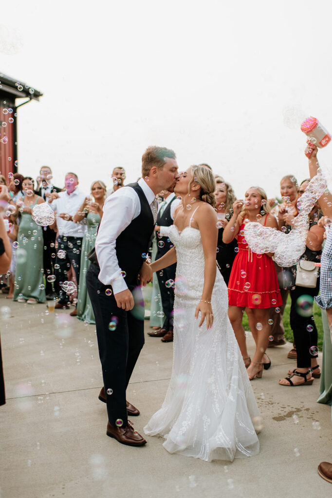 Bride and groom kissing during their bubble wedding exit