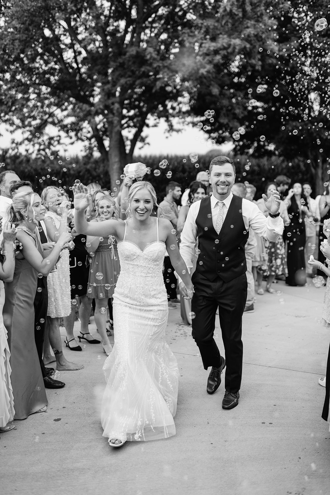 Couple holding hands and laughing as they walk through bubble exit at Rock Run Creek Barn.