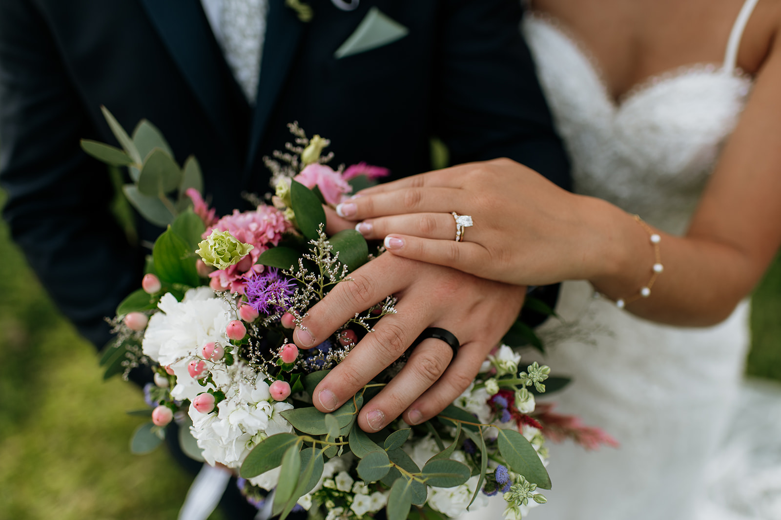 Close up detail shot of the bride and groom showing off their wedding rings
