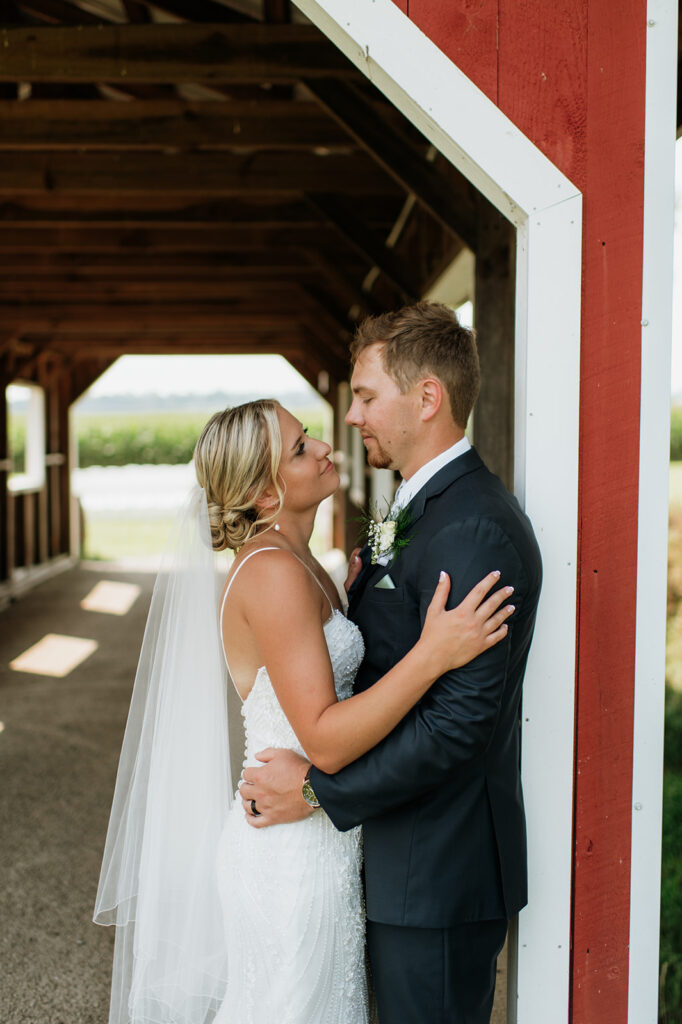 Bride and groom posing at the covered bridge at Rock Run Creek Barn.