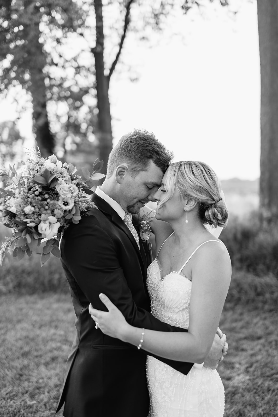 Black and white photo of couple forehead to forehead during golden hour portraits.
