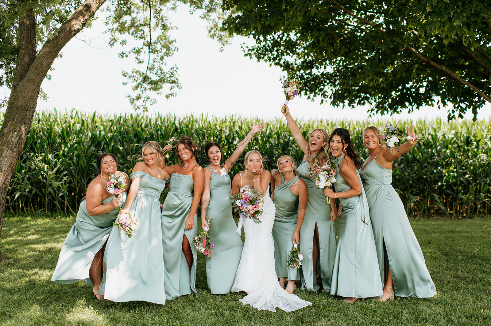 Bridesmaids in mint dresses holding colorful bouquets at Rock Run Creek Barn in Northern Indiana.