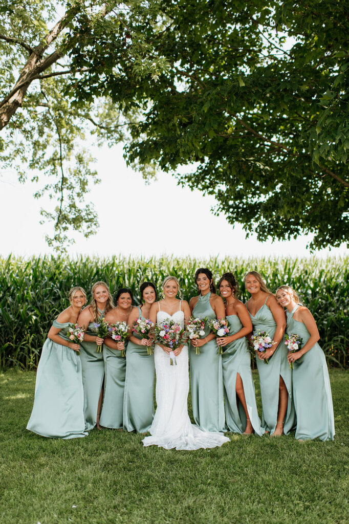 Bridesmaids in mint dresses holding colorful bouquets at Rock Run Creek Barn in Northern Indiana.