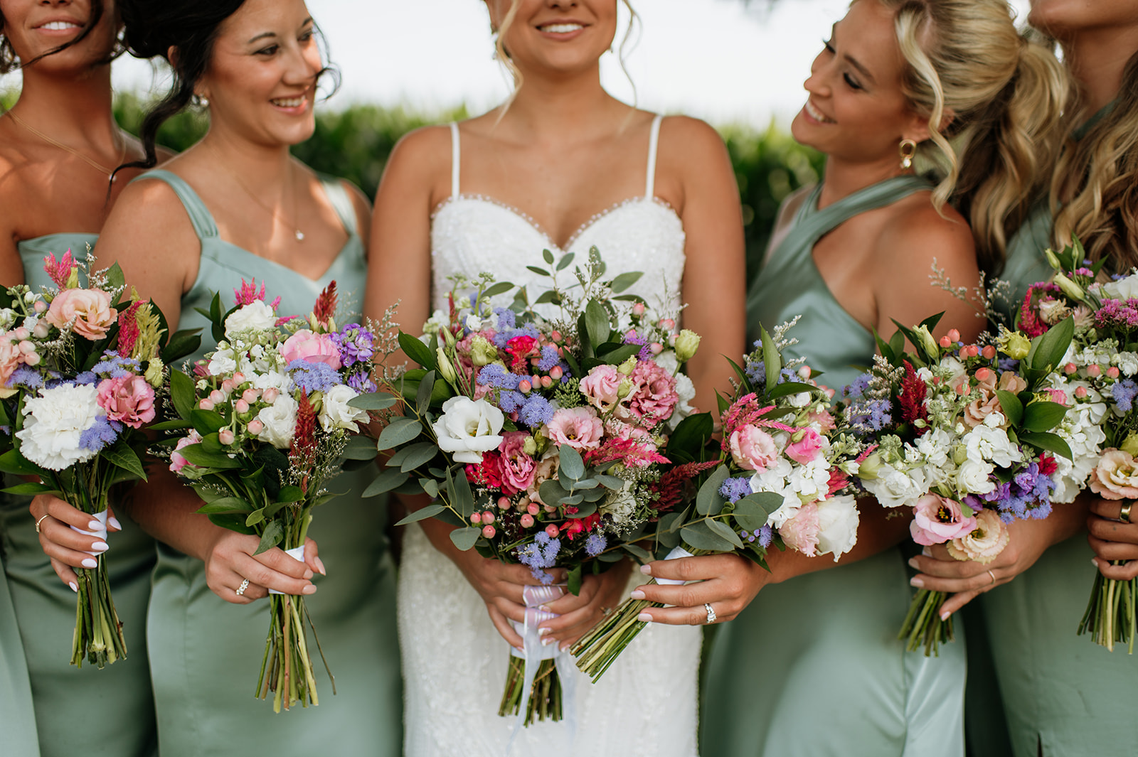 Close-up of bright, colorful bouquets with mint dresses at Rock Run Creek Barn wedding.