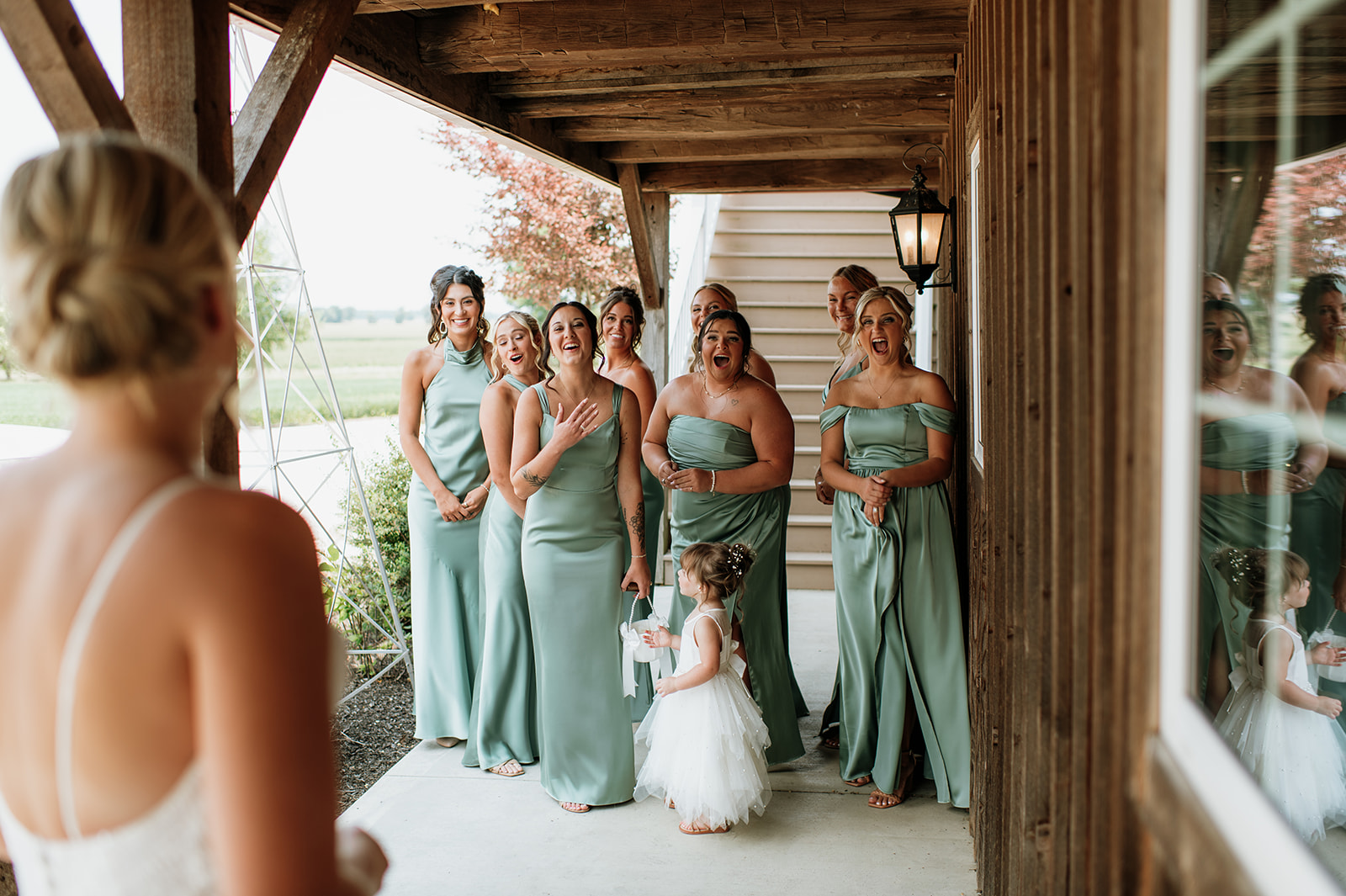 Bridesmaids reacting to seeing the bride for the first time at Rock Run Creek Barn in Goshen, Indiana.