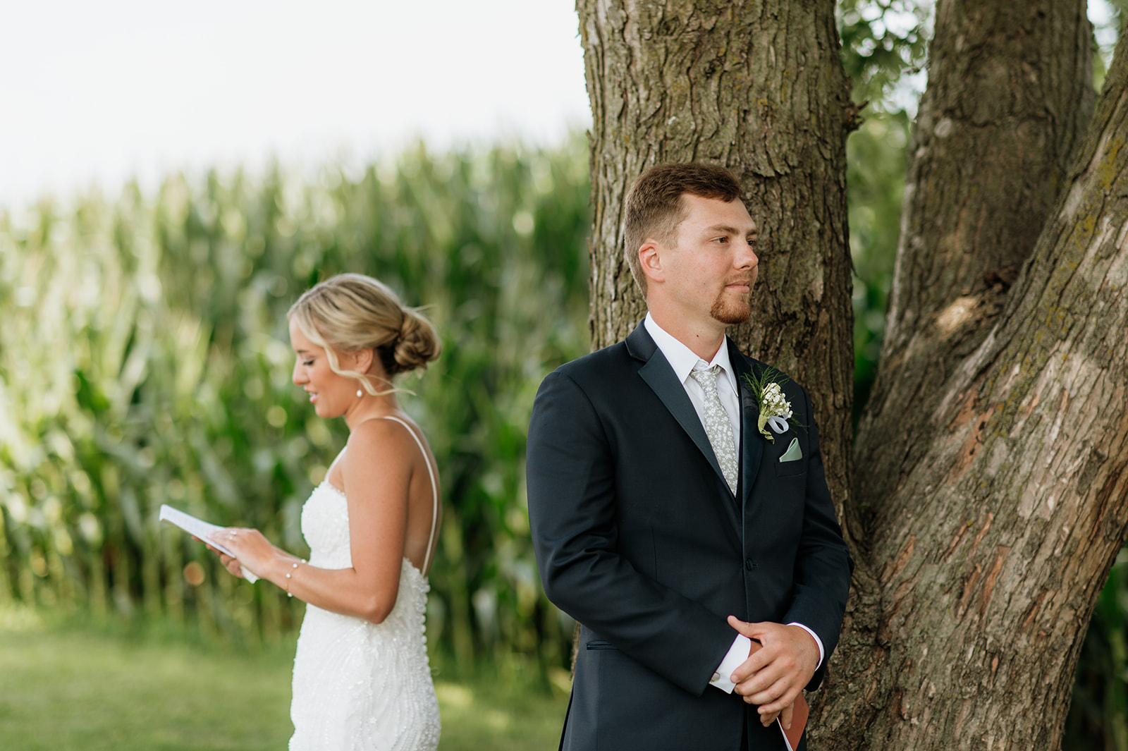 Bride reading her private vows to her groom under a tree