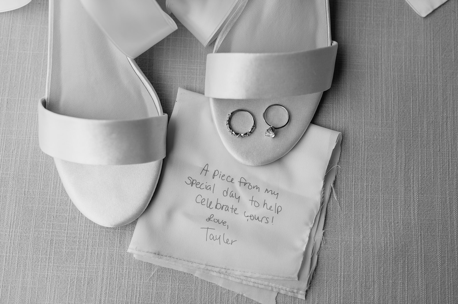 Black and white wedding detail photo of the brides heels, rings, and a handwritten note