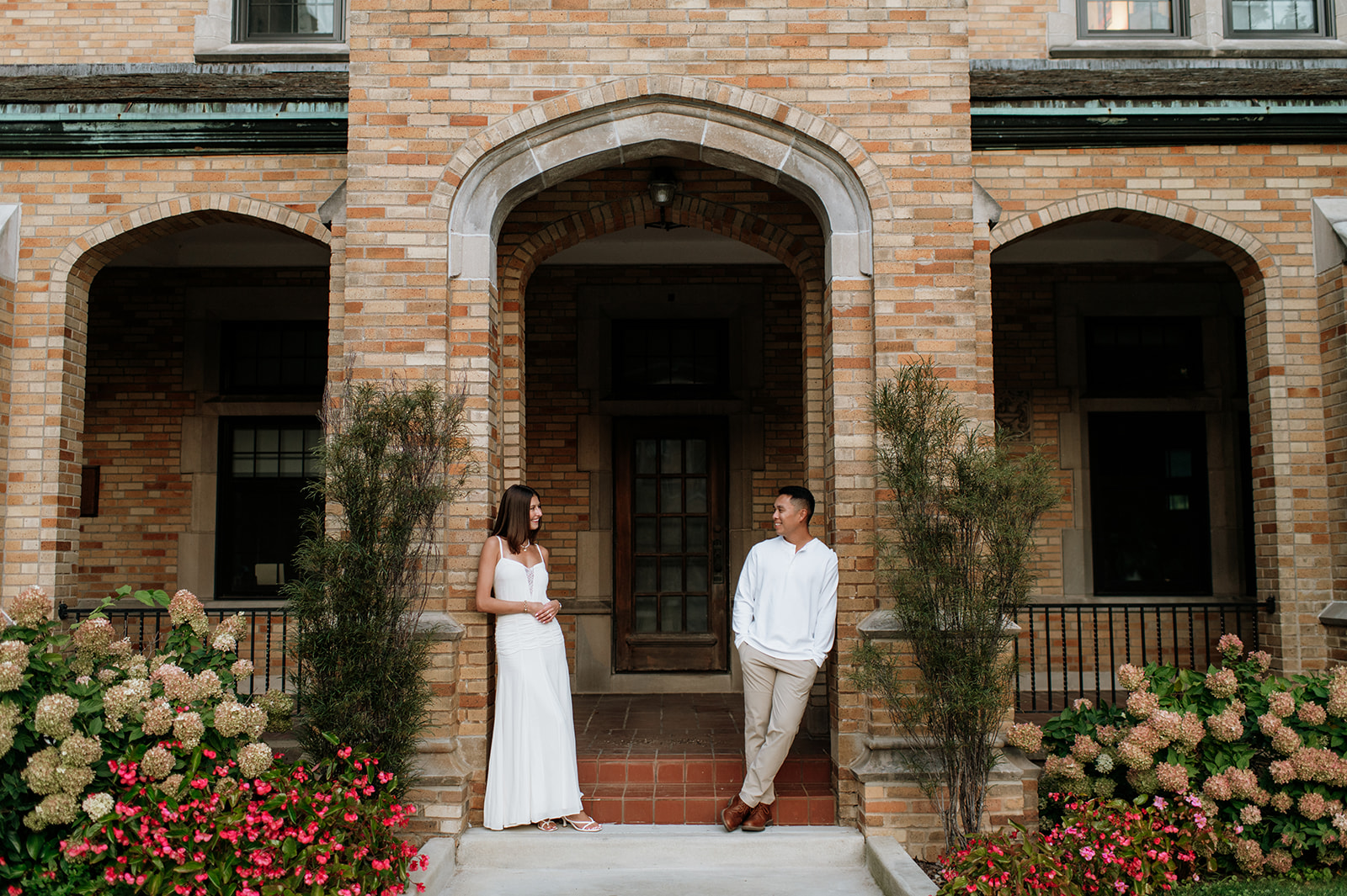 Couple posing in front of the brick archways of LeMans Hall at Saint Mary’s College.