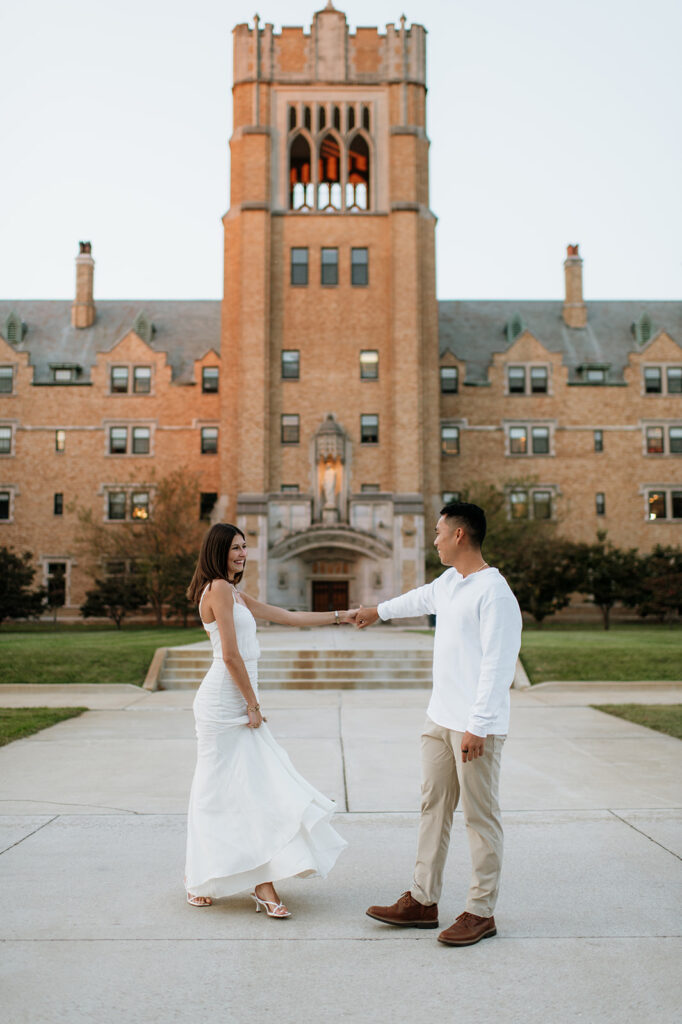 Couple dancing in front of the historic LeMans Hall building during Saint Mary’s College engagement photos.