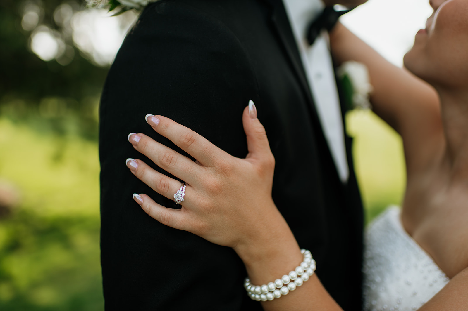 Close up shot of the bride resting her hand on the grooms arm showing off her ring and bracelets.