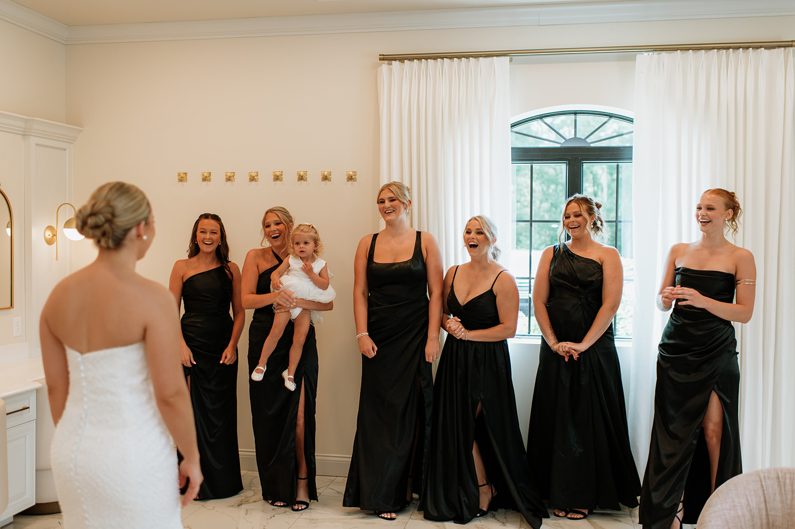 Bridesmaids smiling as they share a first look with the bride