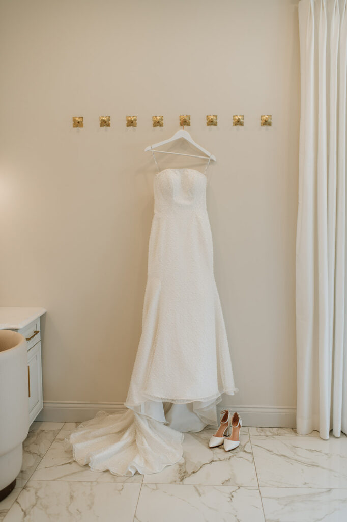 Wedding dress hanging on the wall in the bridal suite at The Clubhouse Venue.