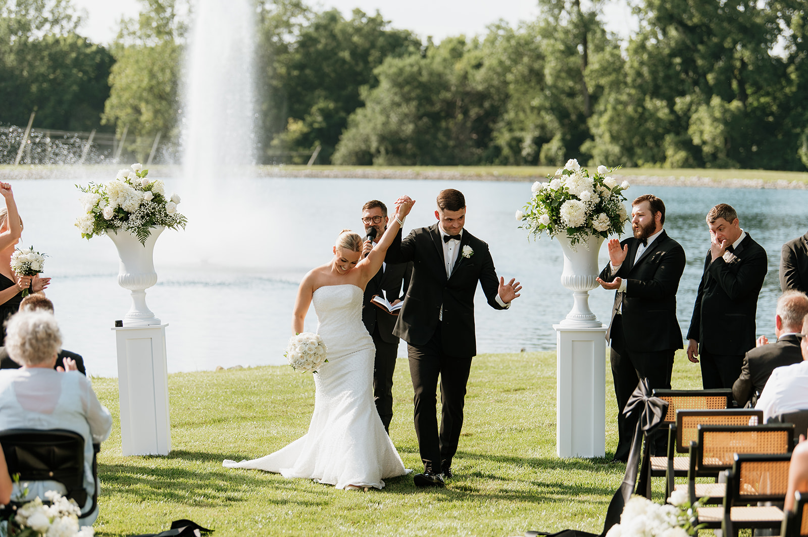 Bride and groom raising their joined hands after being announced as husband and wife at The Clubhouse Venue.