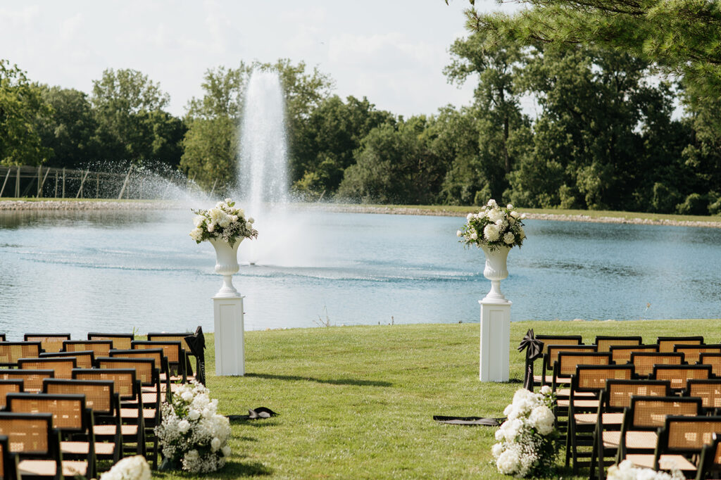 Ceremony setup with floral arrangements and a pond fountain at The Clubhouse Venue.