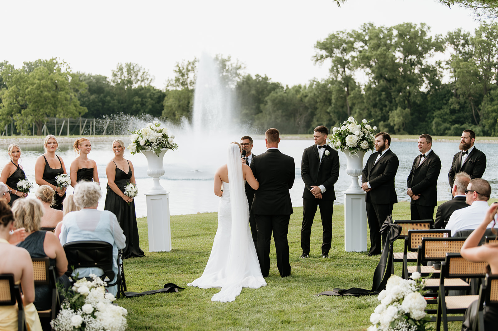 Bride and her father meeting the groom at the altar for an outdoor summer wedding ceremony at The Clubhouse Venue in Huntington, Indiana