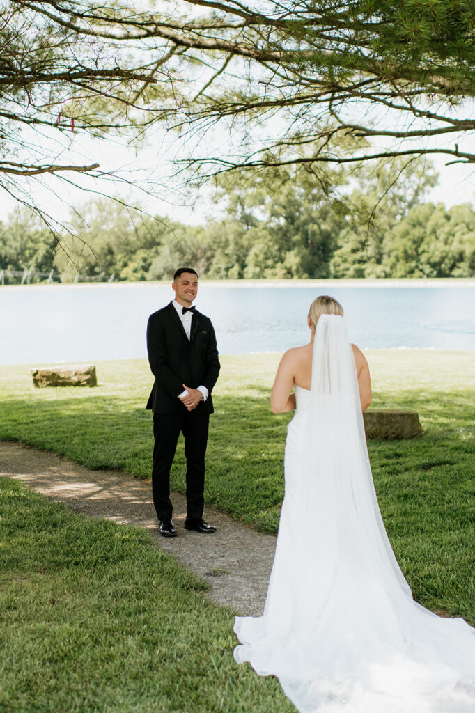 Couple sharing a first look by the lake on the grounds of The Clubhouse Venue.