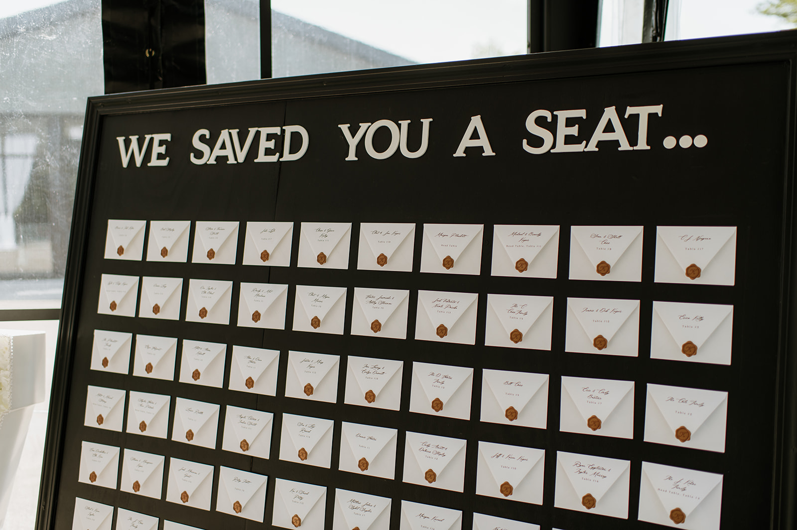 Black seating chart display with envelope place cards at The Clubhouse Venue.