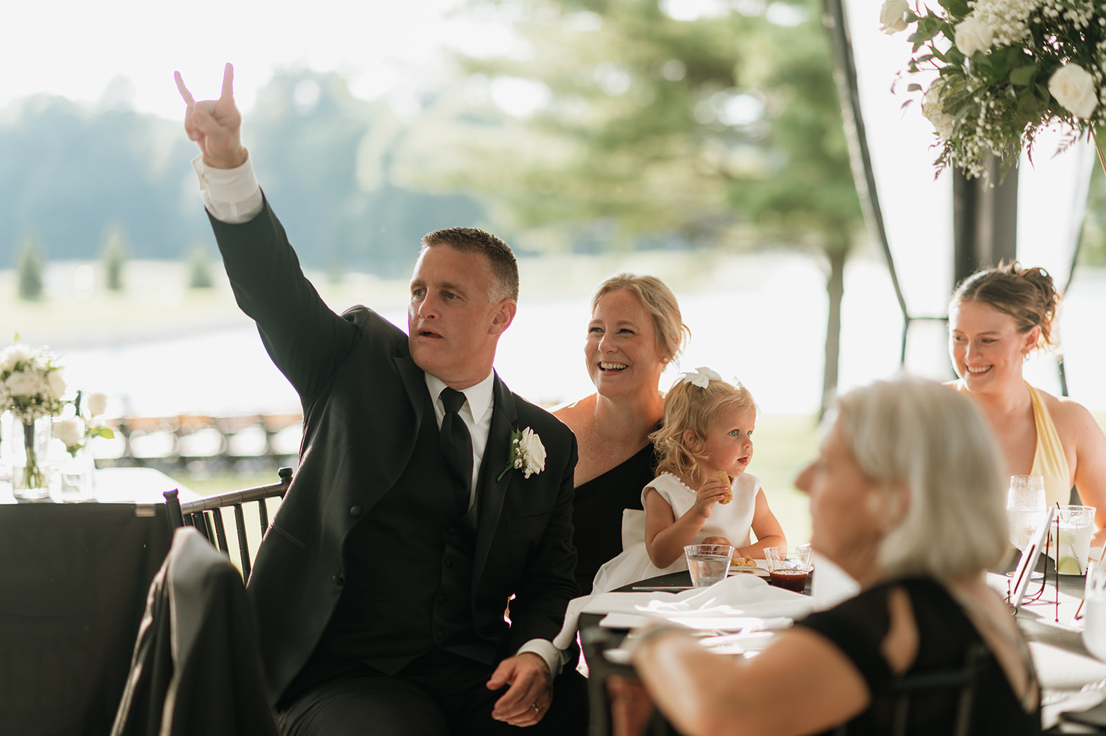 Bride of the father and family raising hands in the air for their wedding entrances