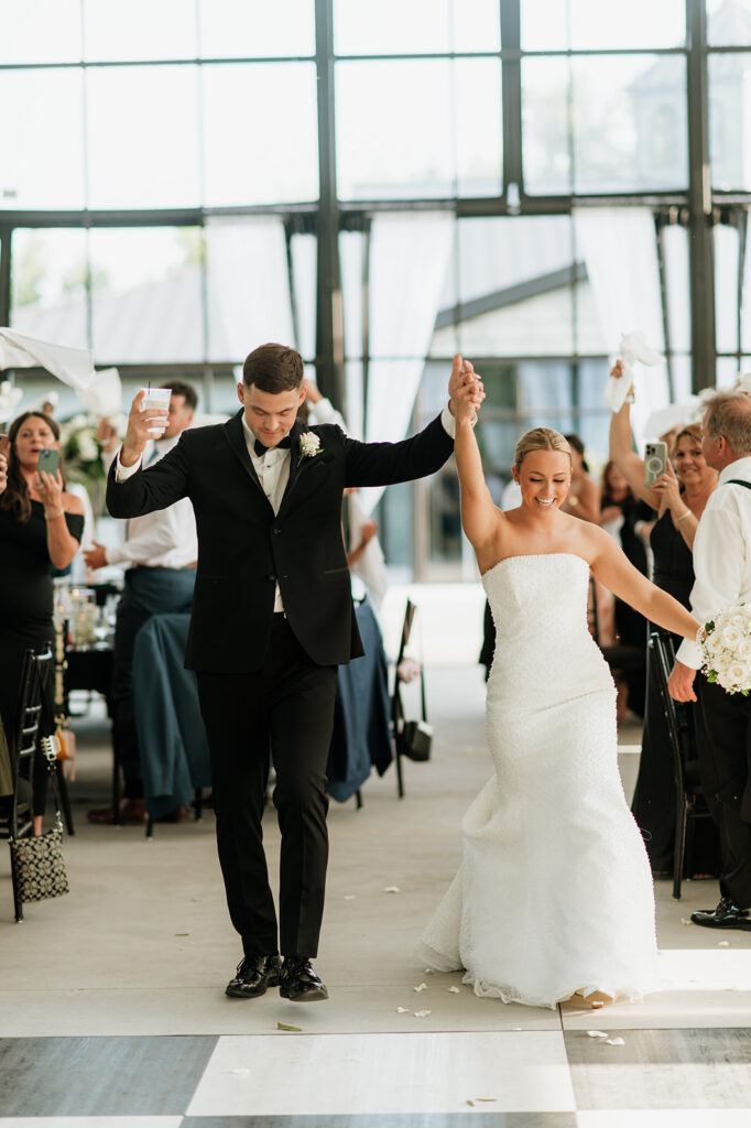 Bride and groom entering The Clubhouse Venue reception hand in hand.