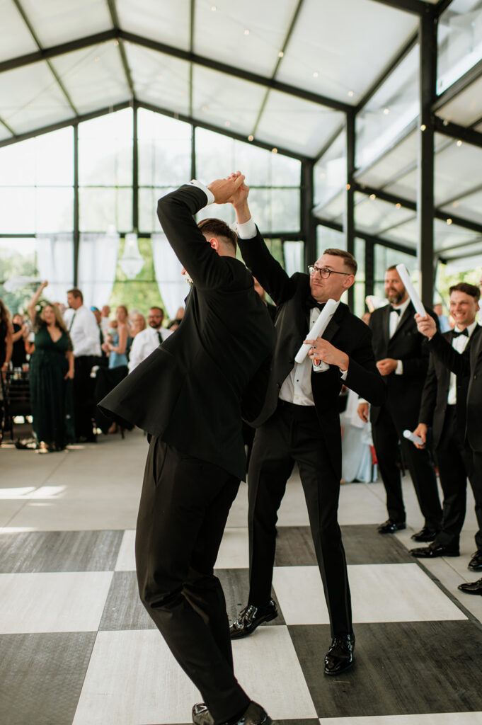 Groomsmen twirling the groom during his reception entrance