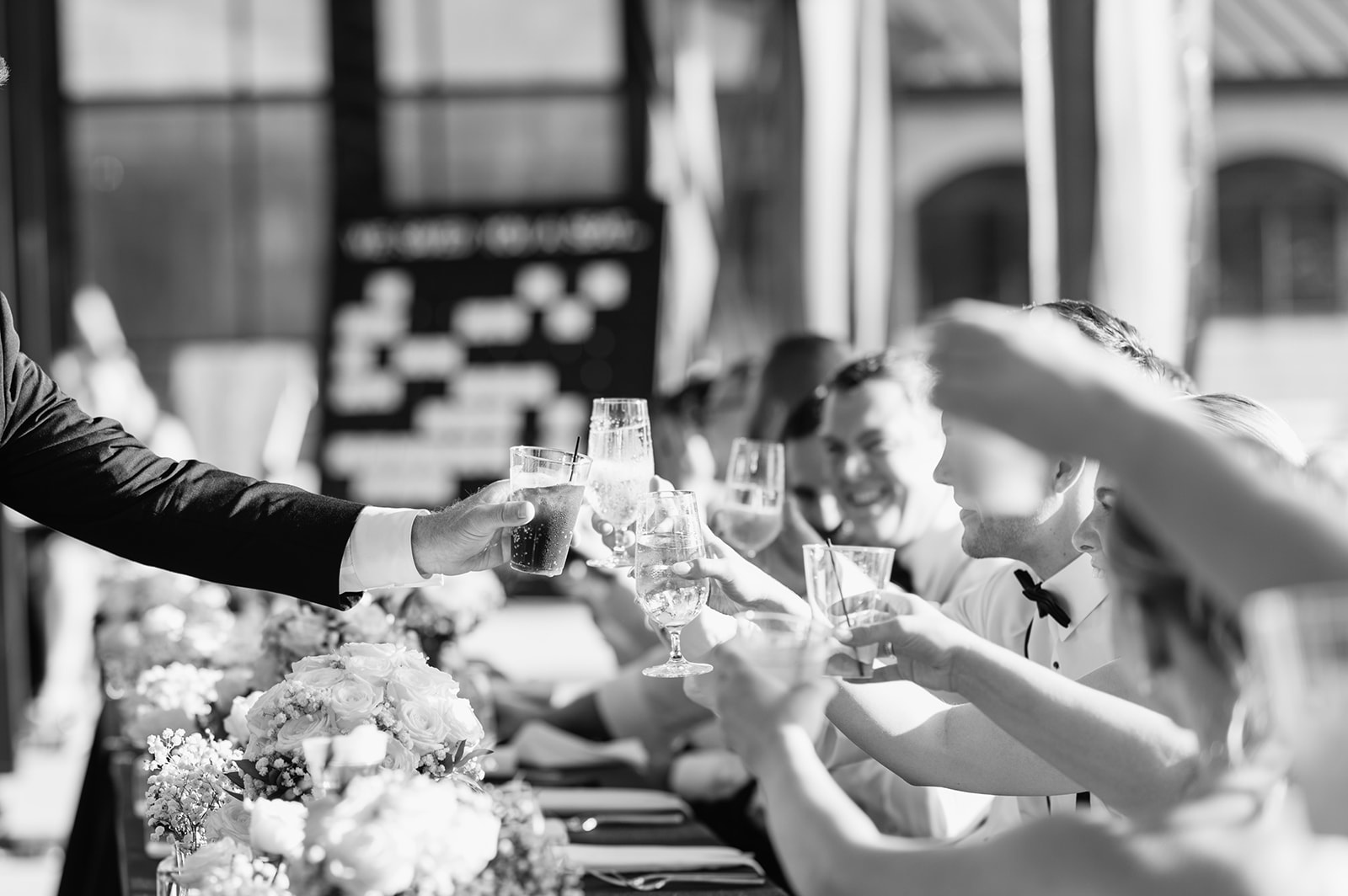 Black and white candid photo of the bride and groom toasting during speeches