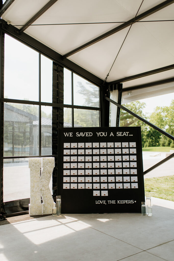 Black seating chart display with envelope place cards at The Clubhouse Venue.