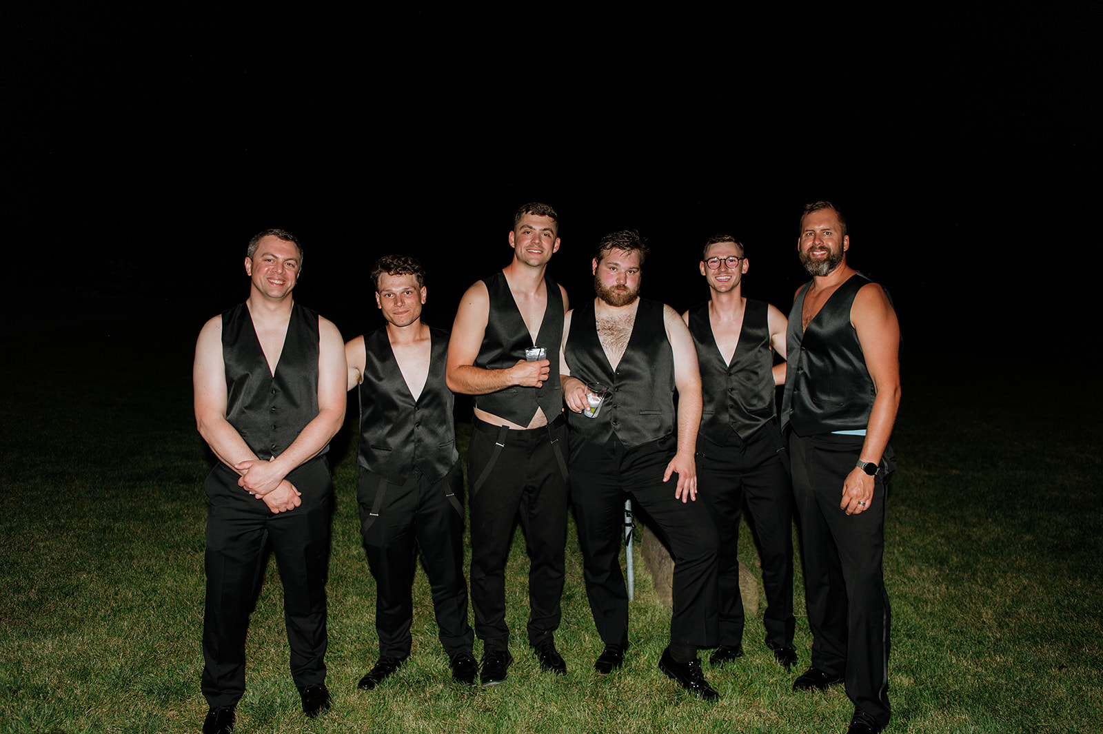 Groom and groomsmen wearing vests with no shirts underneath