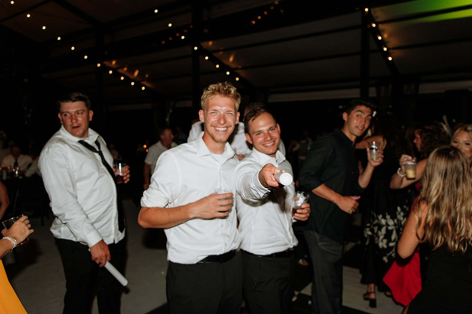 Guests smiling and pointing to the camera while dancing