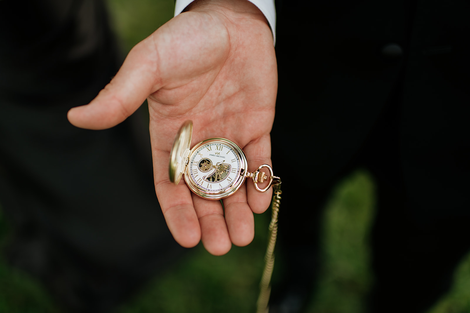 Groom holding his pocket watch