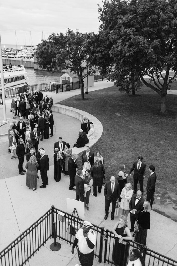 Black and white photo of guyests waiting to board Anita Dee II for a Chicago yacht wedding.