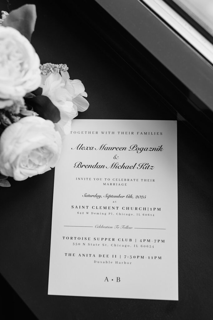 Bride’s wedding invitation styled with white florals in a Chicago hotel room.